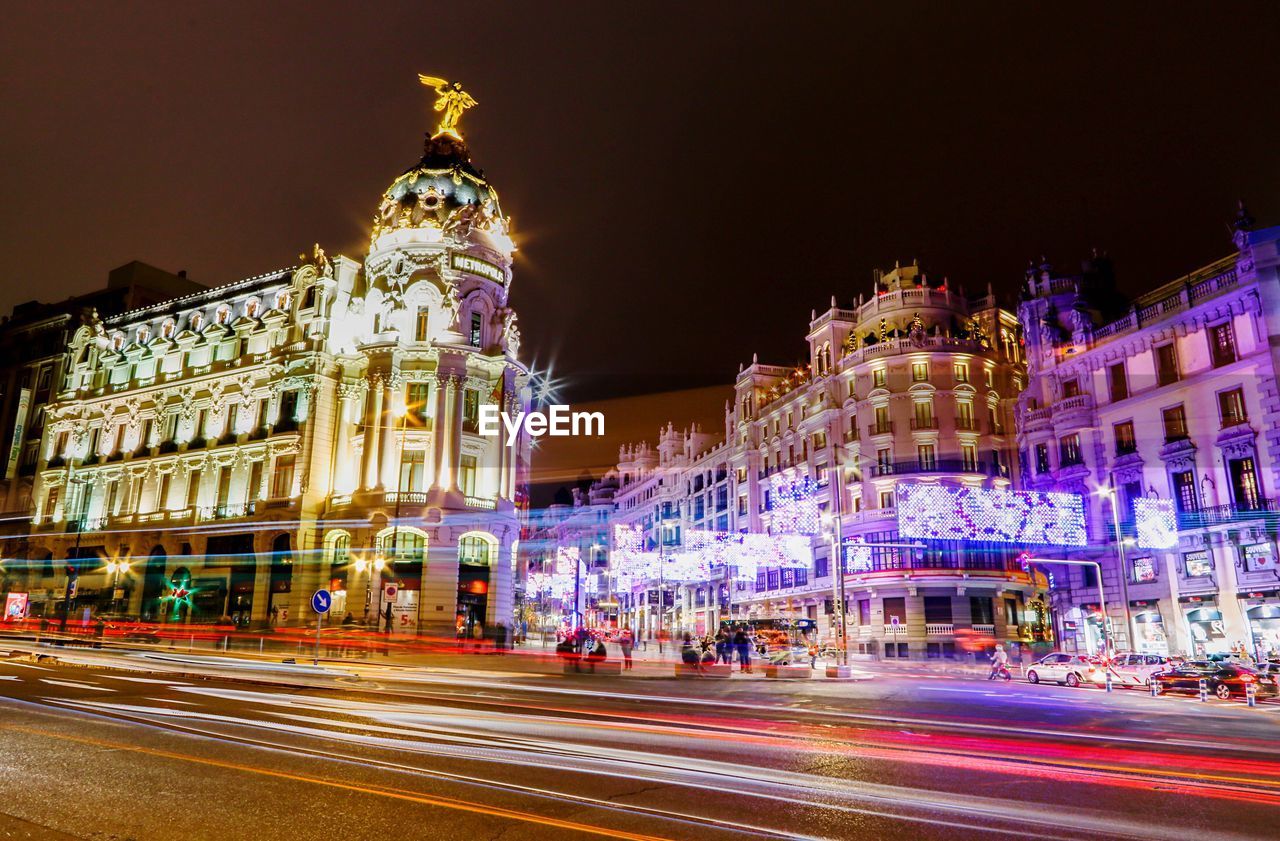 LIGHT TRAILS ON STREET AT NIGHT