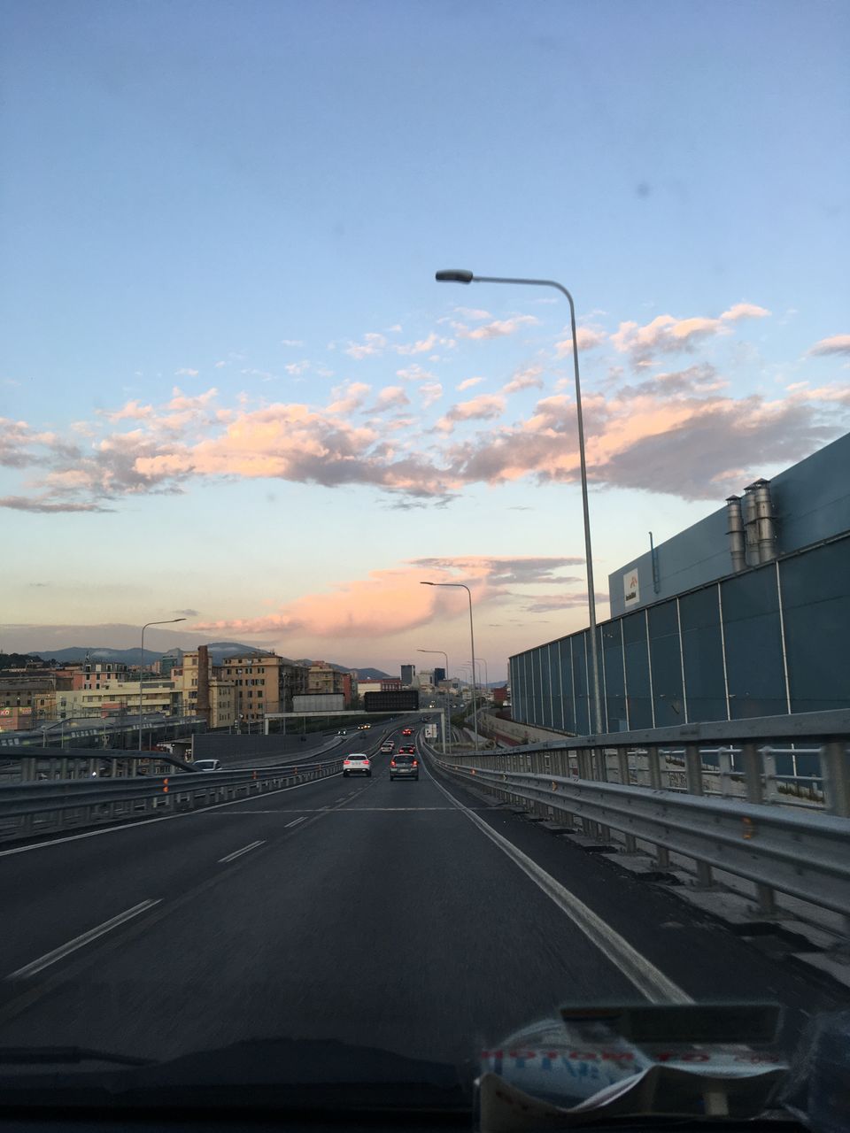 CARS ON ROAD AGAINST SKY AT SUNSET