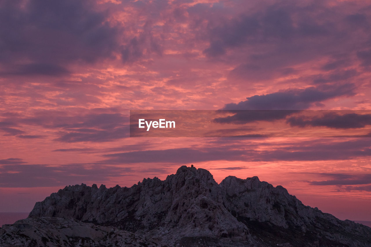 Rock formation against sky during sunset