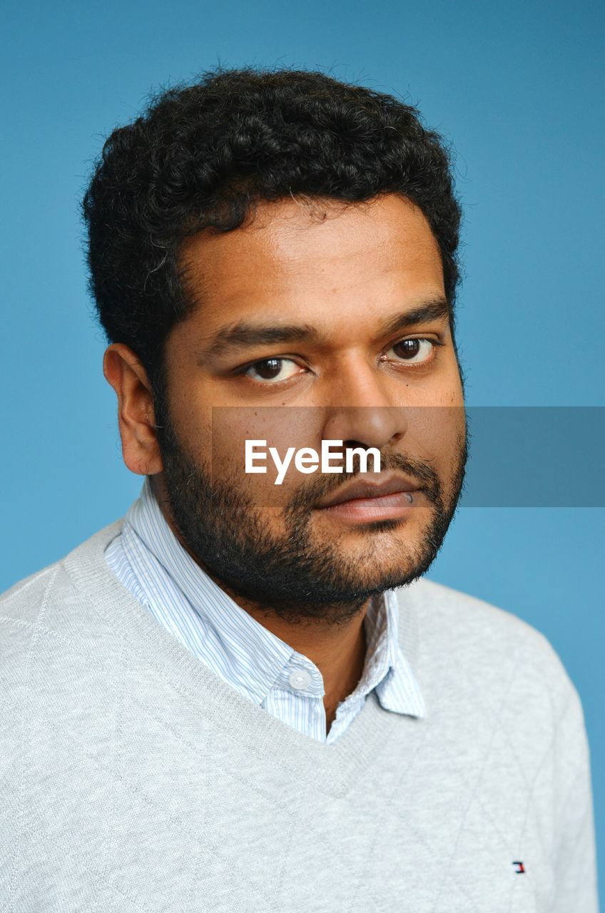 Portrait of mid adult man against blue background