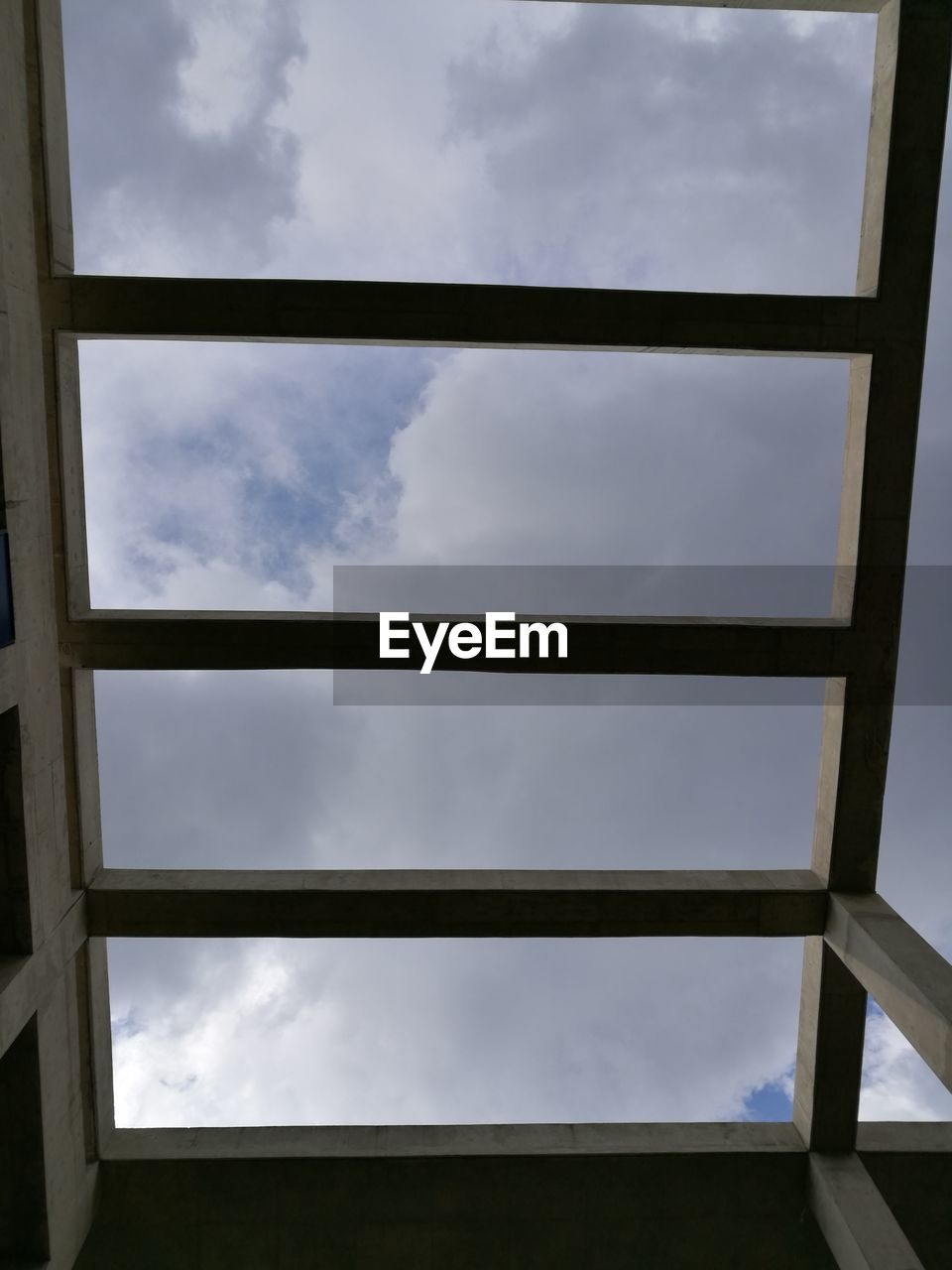 LOW ANGLE VIEW OF CLOUDY SKY SEEN THROUGH WINDOW