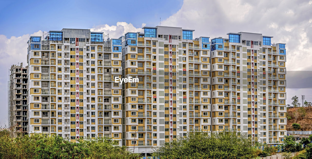 Colorful tall building ready construction with clear blue sky background in pune, maharashtra.