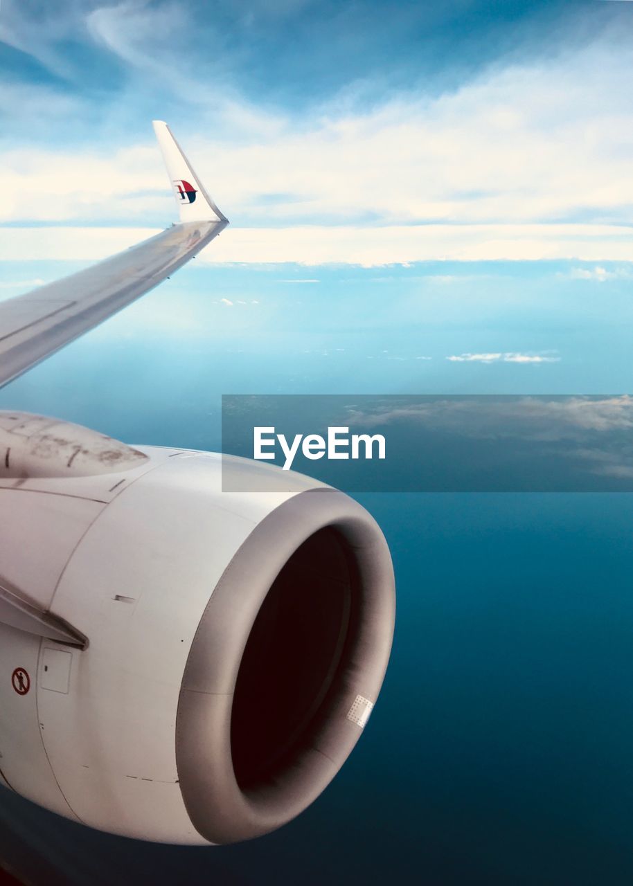 Airplane flying over clouds against sky