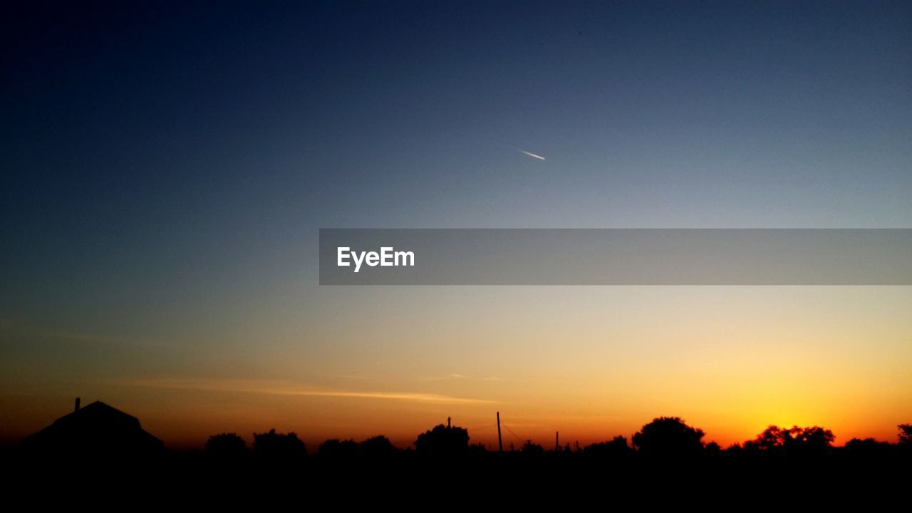 SILHOUETTE LANDSCAPE AGAINST CLEAR SKY DURING SUNSET