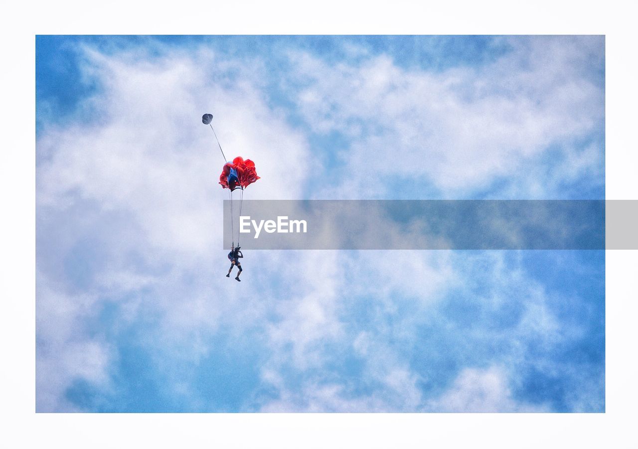 LOW ANGLE VIEW OF PARAGLIDING AGAINST BLUE SKY