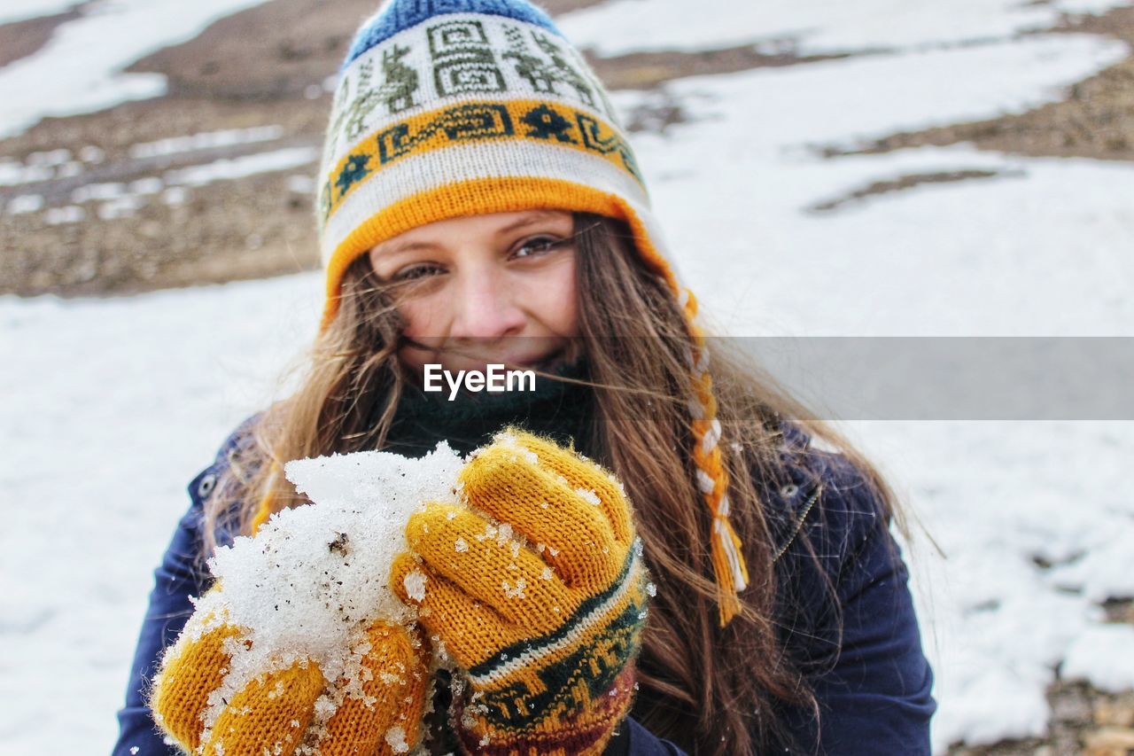 Portrait of smiling woman holding snow