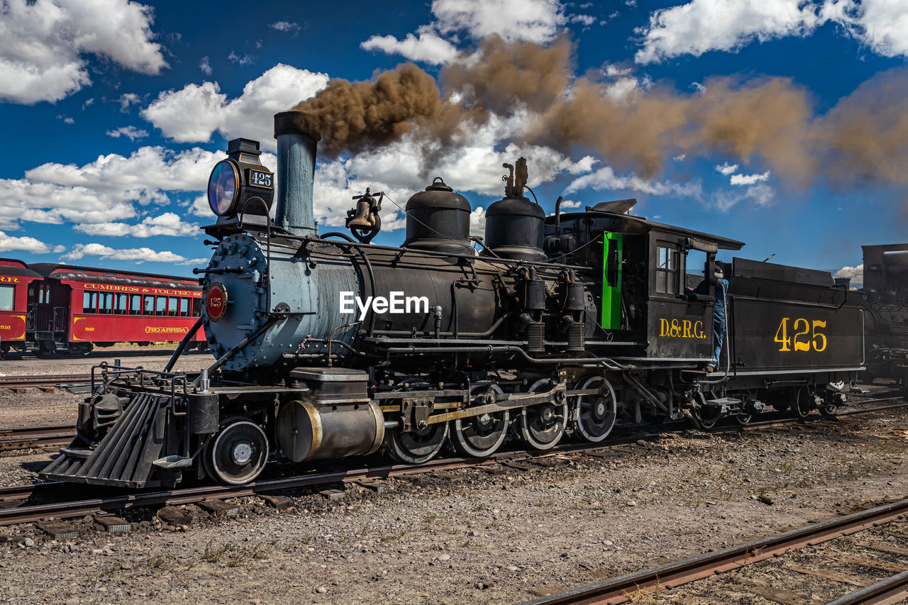 rail transportation, transportation, locomotive, train, railroad track, railway, track, mode of transportation, transport, vehicle, cloud, sky, land vehicle, steam train, nature, smoke, public transportation, travel, no people, day, outdoors, rolling stock, steam engine