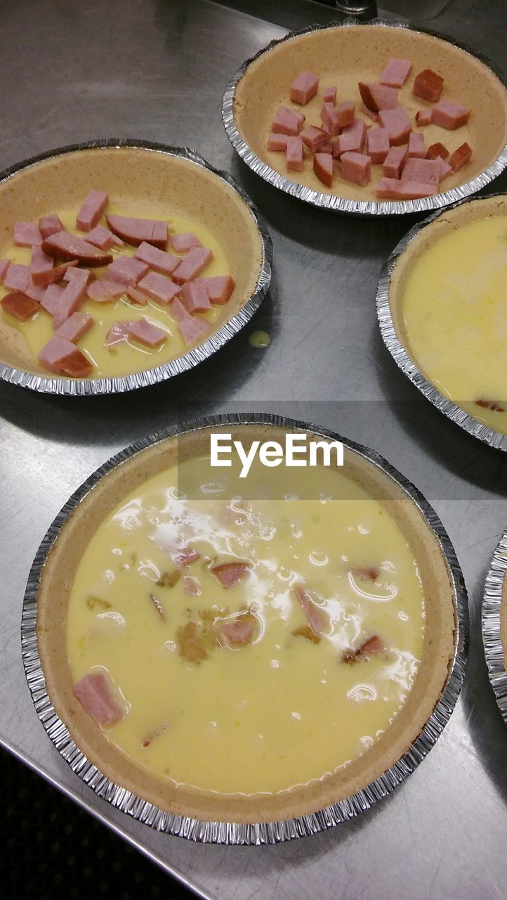 High angle view of batter and chopped meat in containers on table