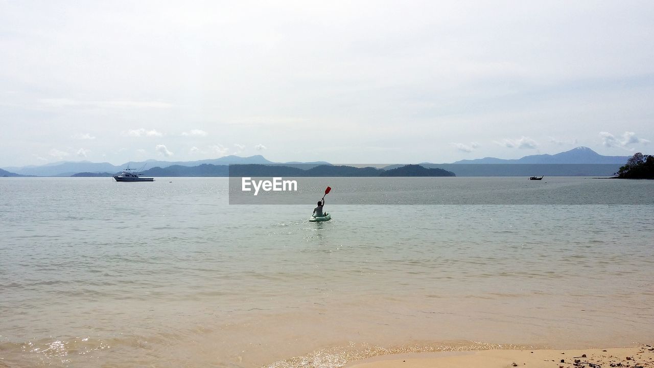 MAN ON SEA AGAINST SKY