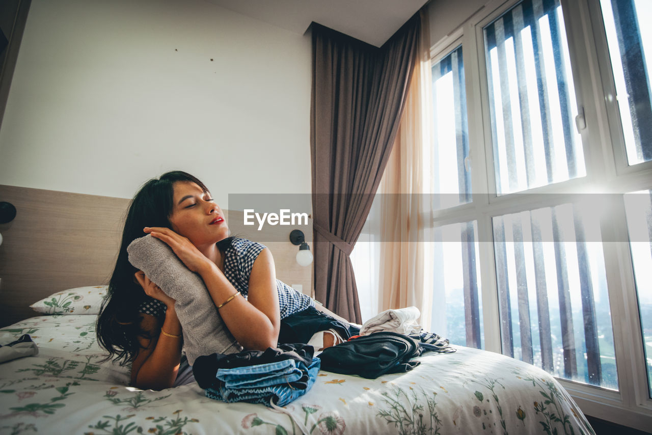 Young woman lying on bed at home