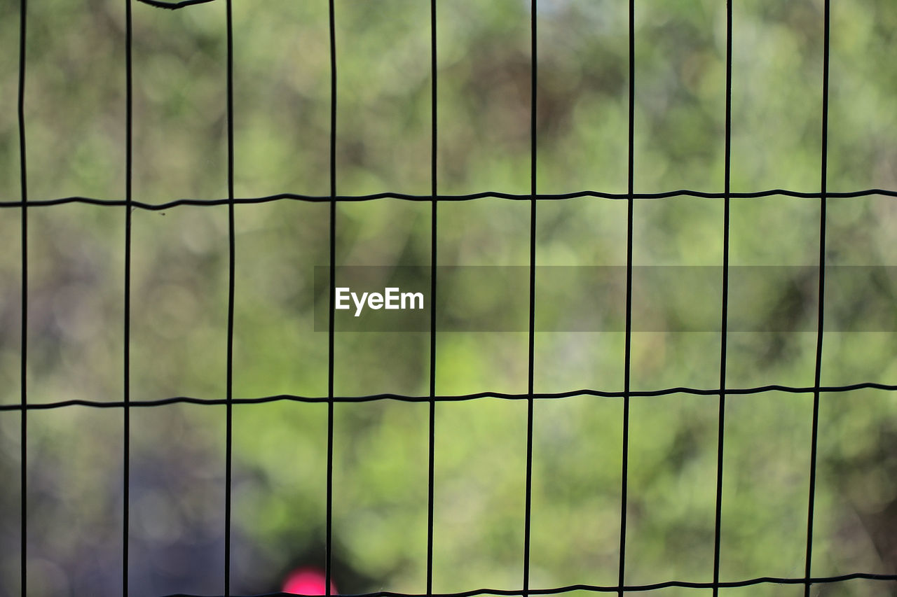 FULL FRAME SHOT OF FENCE ON METAL GRATE