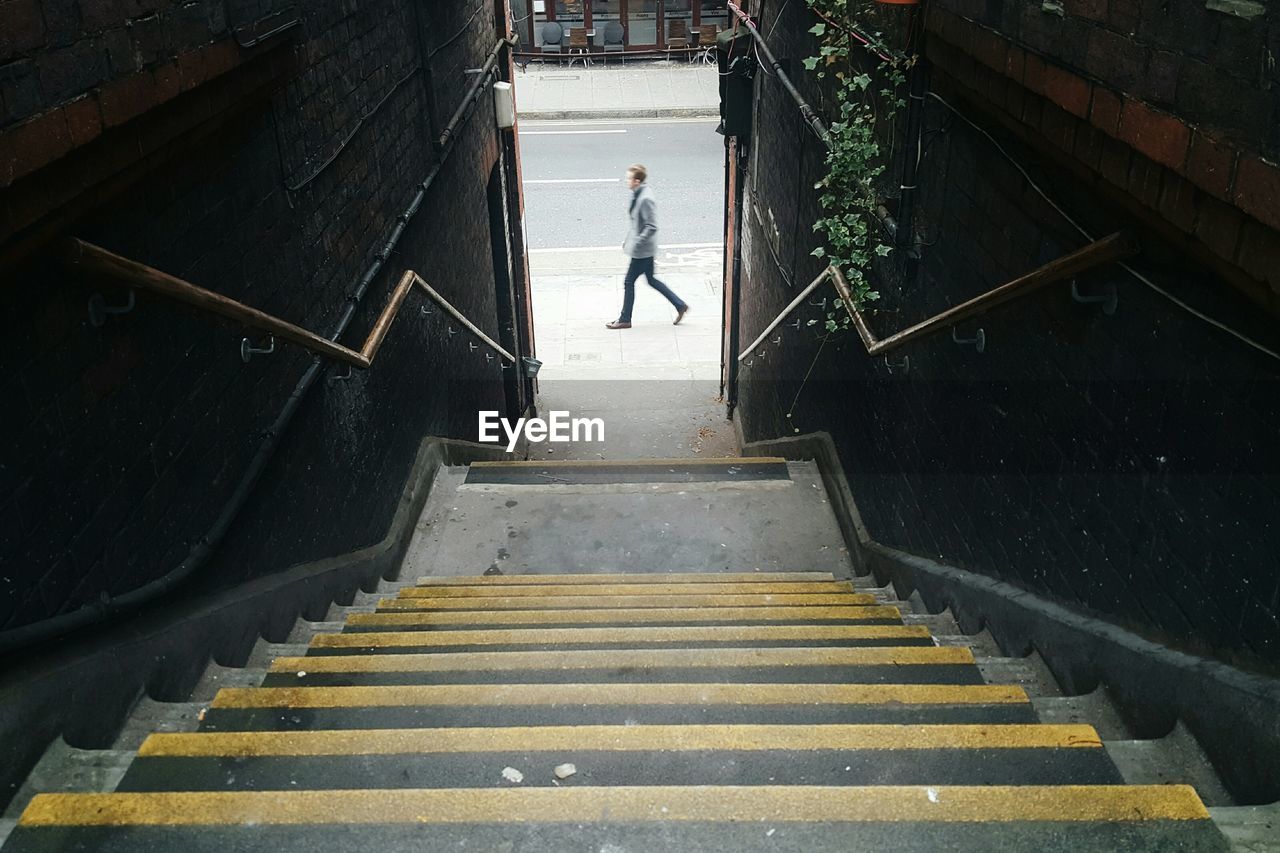 High angle view of man walking on footpath