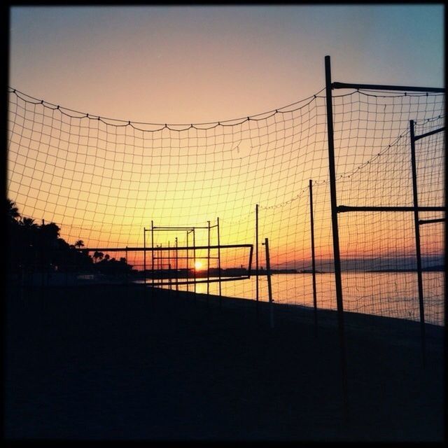 Silhouette nets by sea against clear sky during sunset