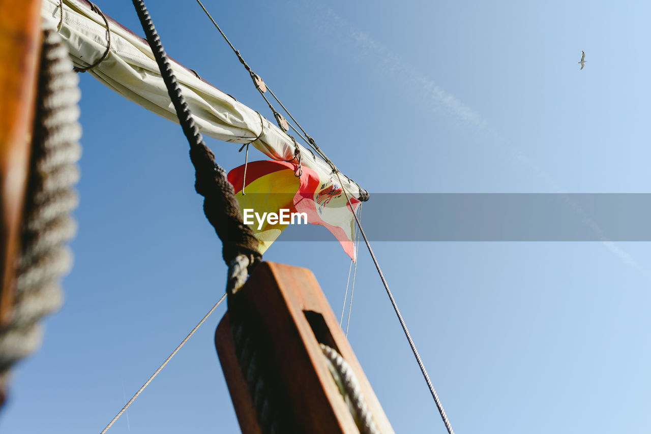 LOW ANGLE VIEW OF FLAGS HANGING AGAINST SKY