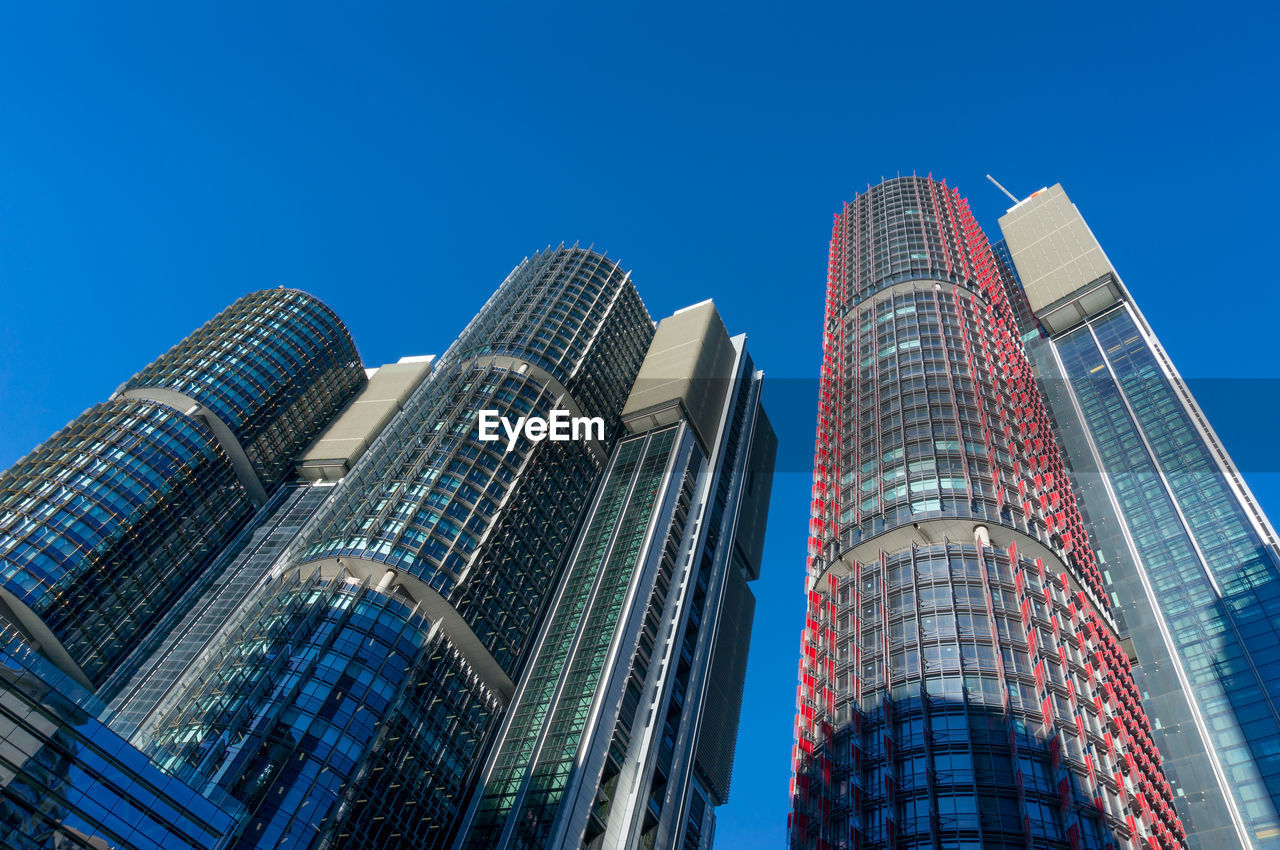 Low angle view of modern buildings against blue sky.