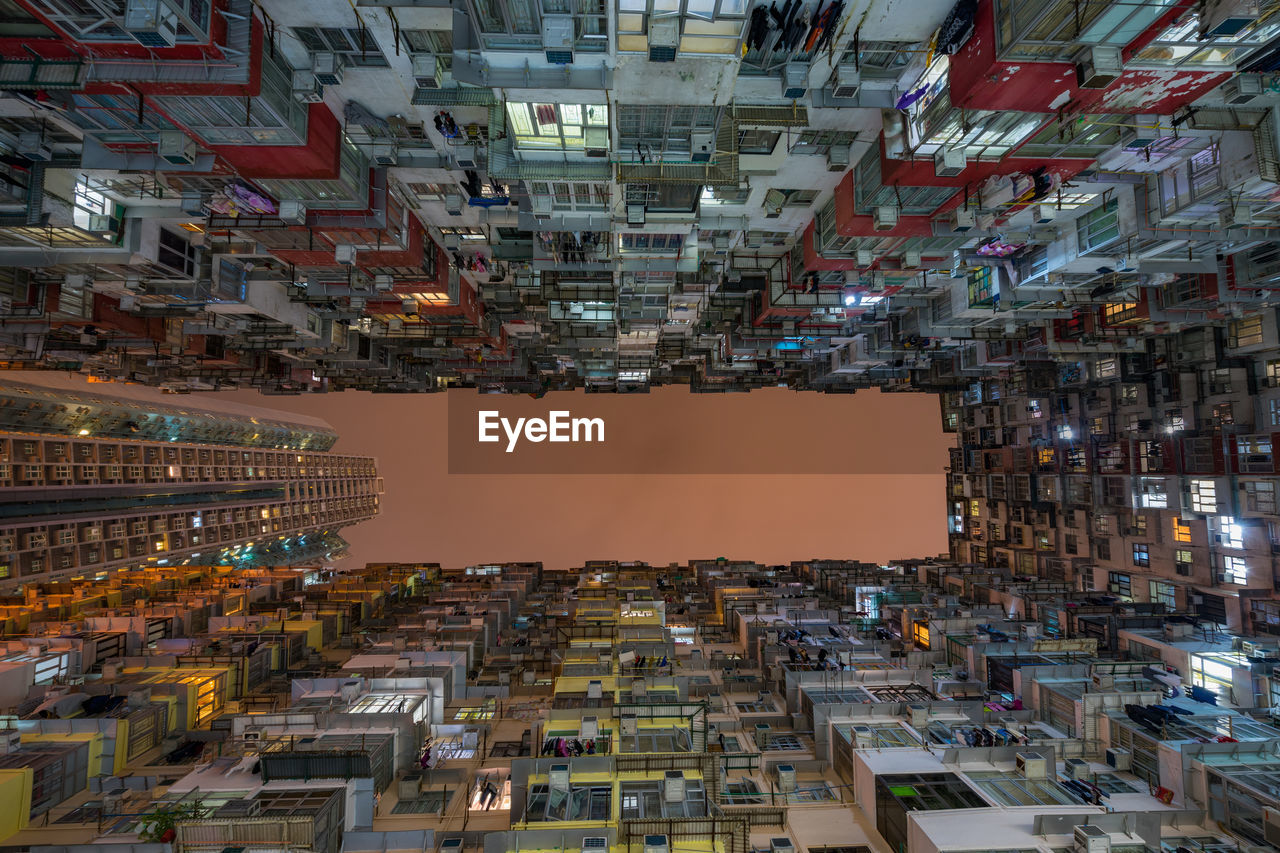 Directly below shot of buildings against clear sky during sunset