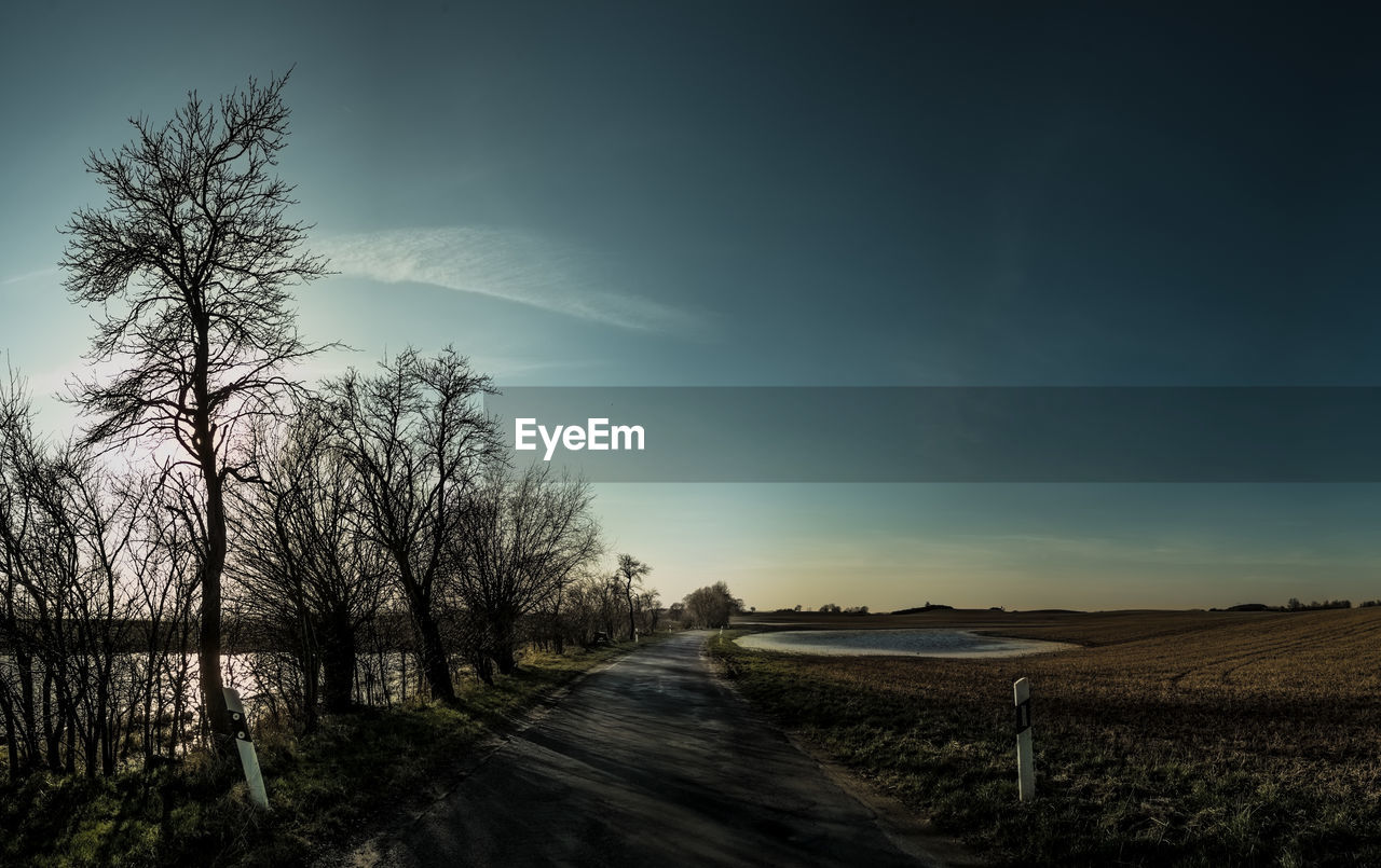 Road amidst field against sky