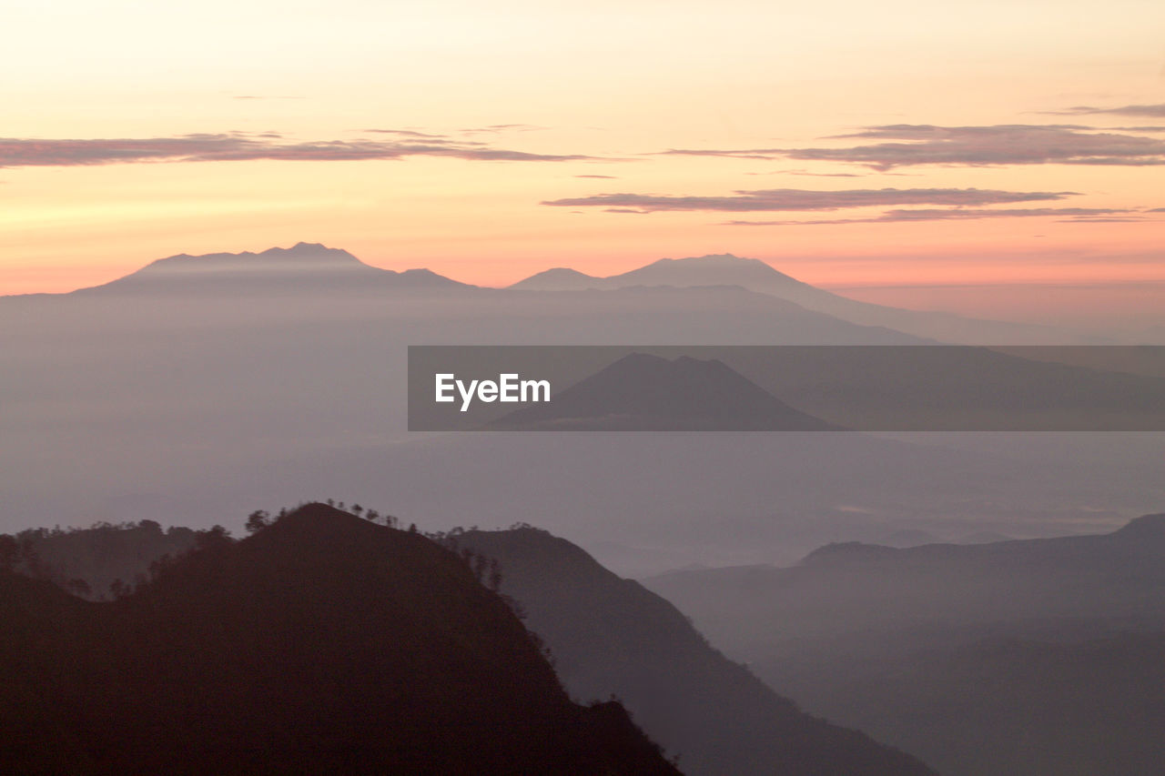 Scenic view of mountains against sky at sunset