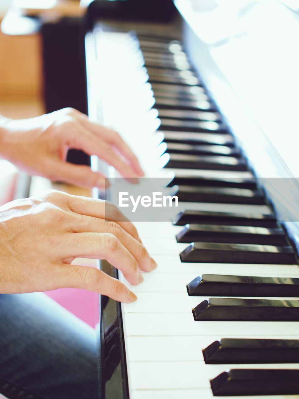 Cropped hands of person playing piano