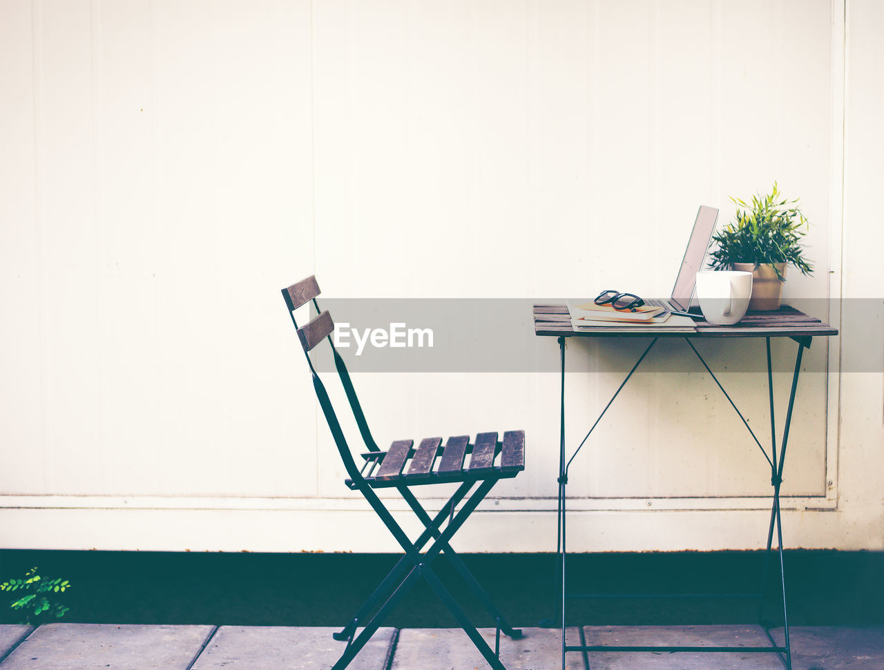 EMPTY CHAIR ON TABLE BY WALL