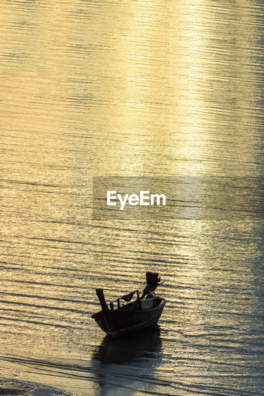 HIGH ANGLE VIEW OF MAN ON BOAT AT SEA