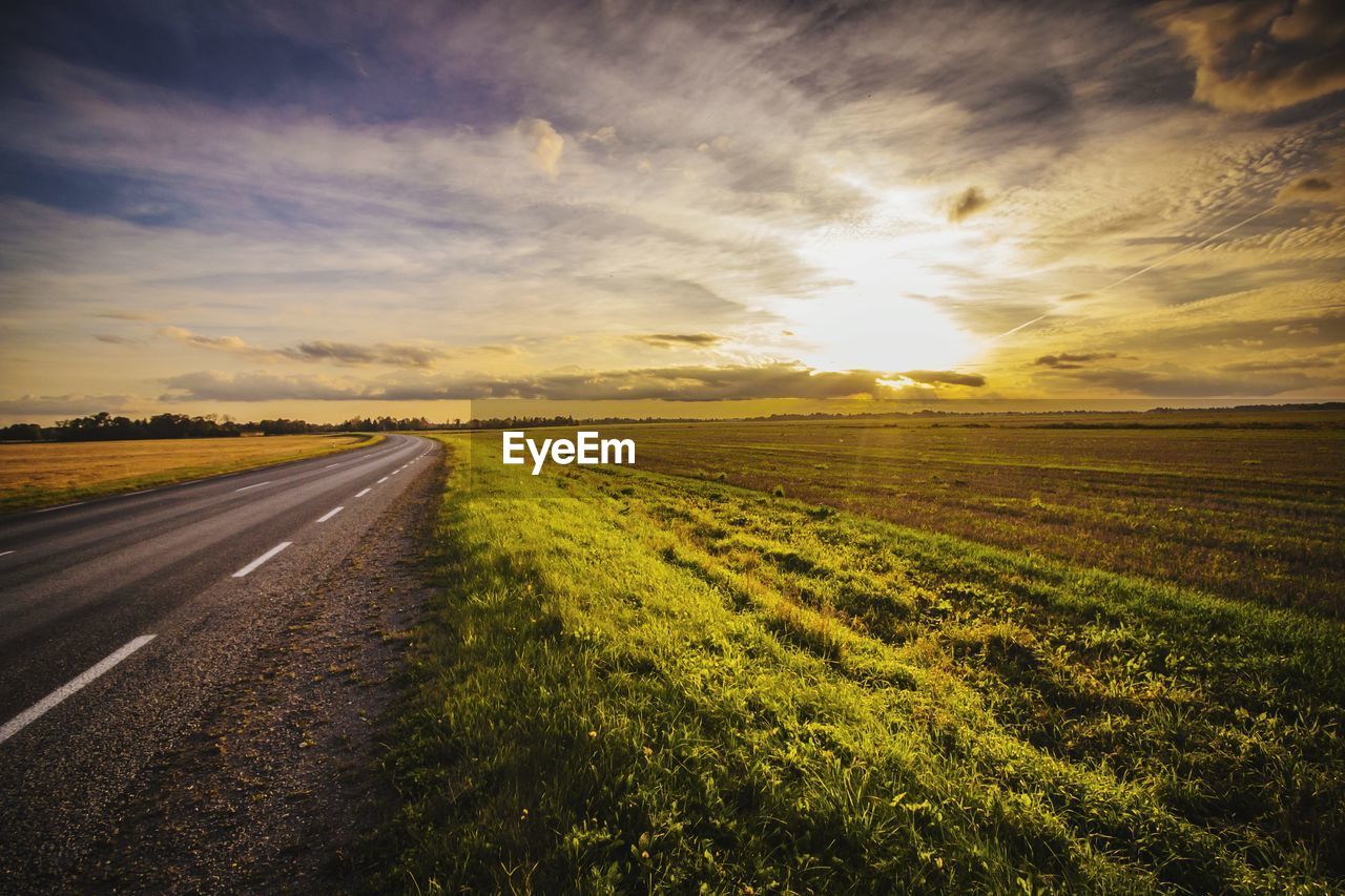 Scenic view of agricultural field against sky during sunset