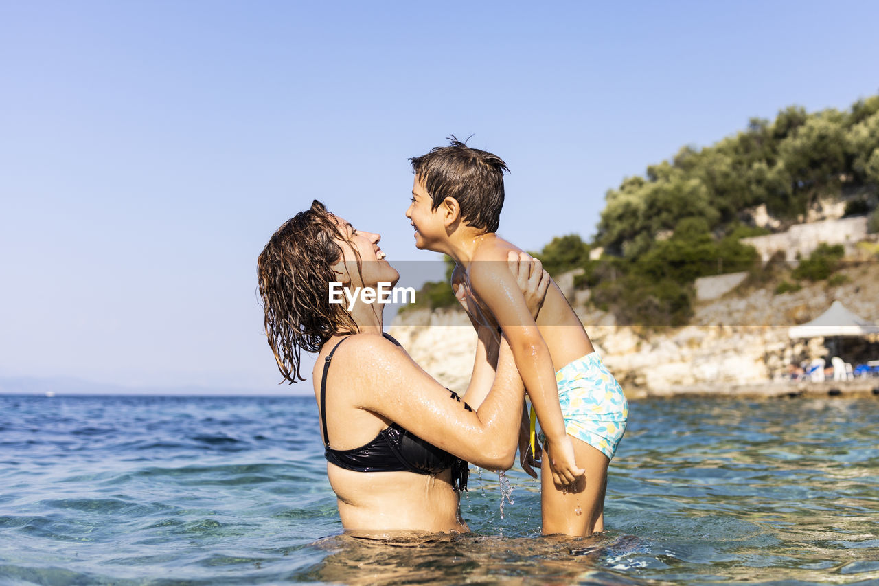 Mother and son having fun into the sea