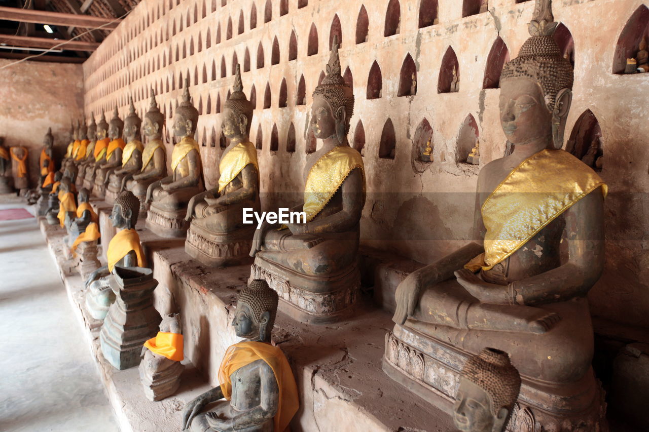 Buddha statues against wall in temple