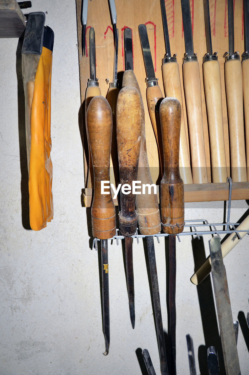 Close-up of clothes hanging on wood against wall