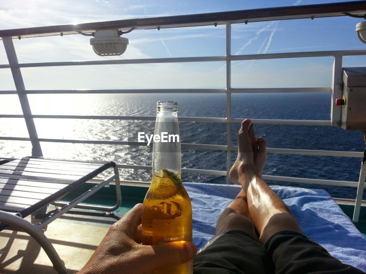 Low section of man relaxing on boat deck