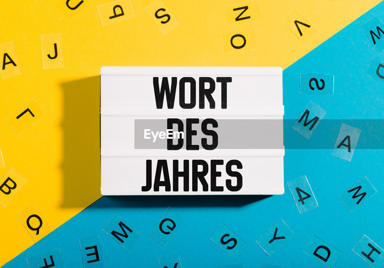 Symbolbild zu wort des jahres mit gelb blauem papier untergrund für deutsche grammatik und sprache