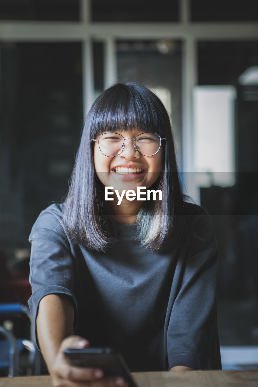 Portrait of smiling young woman using smart phone