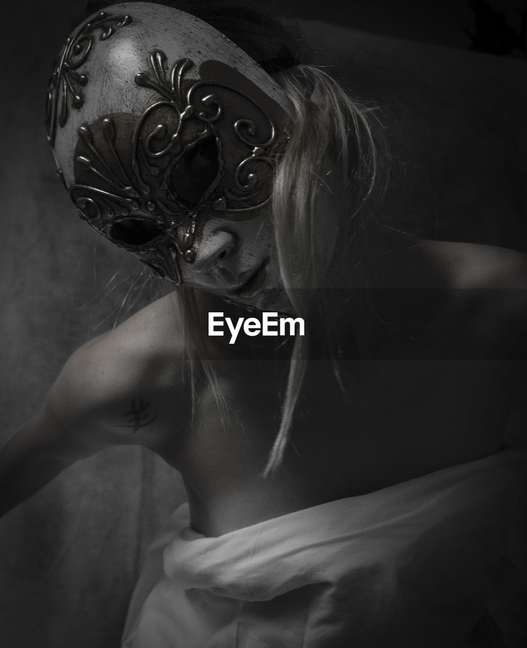 Portrait of woman wearing mask in darkroom