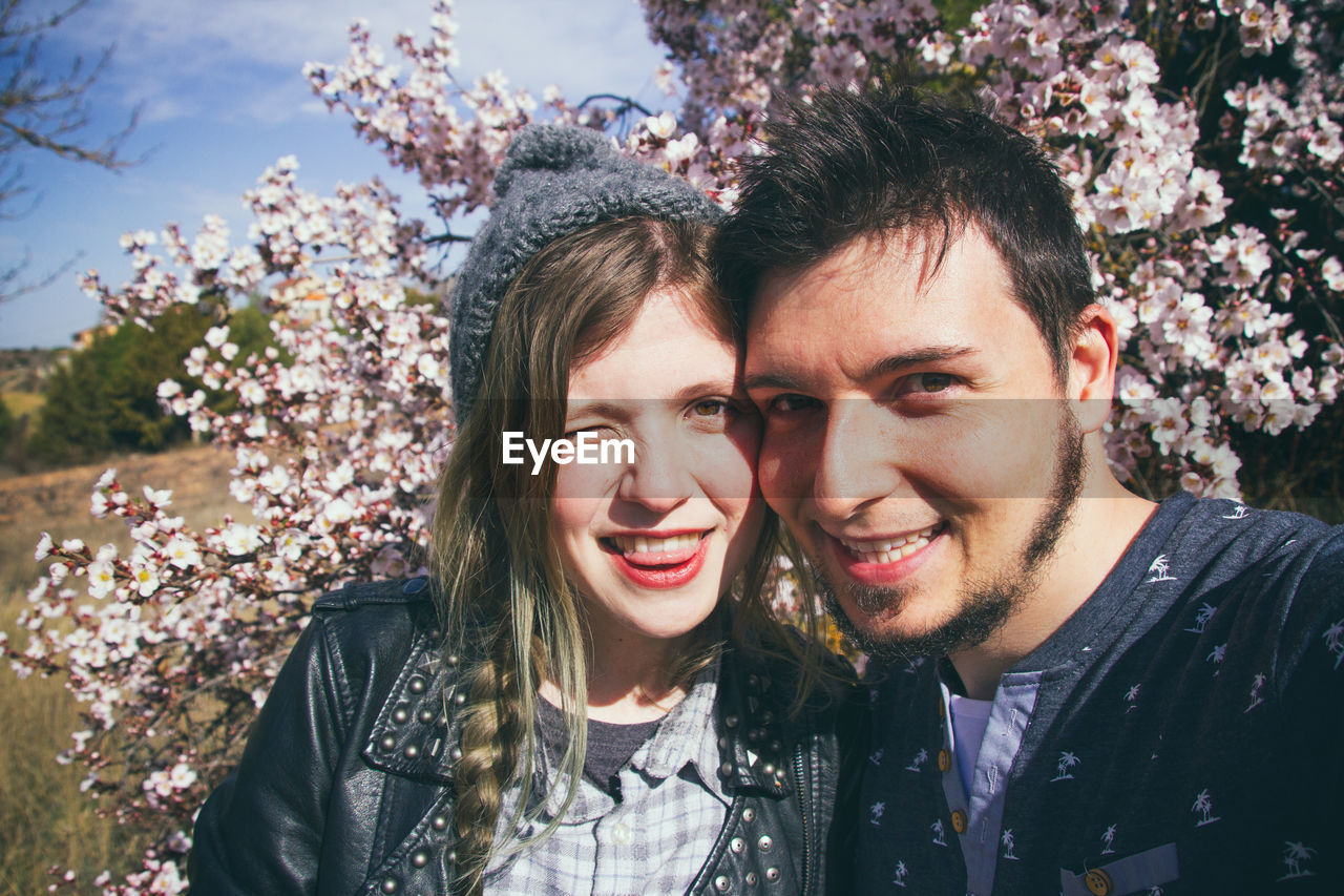 Portrait of smiling young couple standing at park