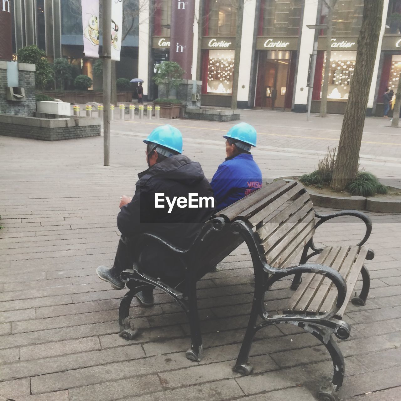 FULL LENGTH OF FATHER SITTING ON BENCH IN PARK