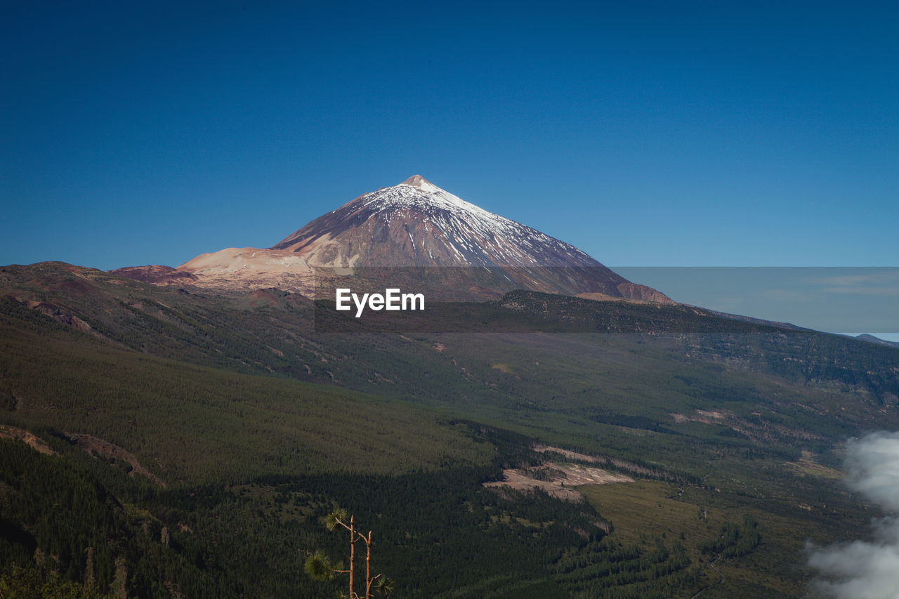 SCENIC VIEW OF VOLCANIC MOUNTAIN AGAINST BLUE SKY