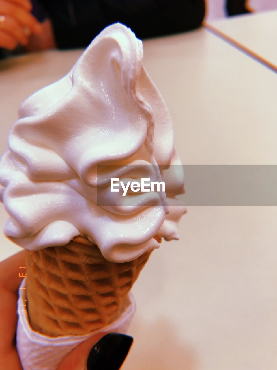 CLOSE-UP OF A HAND HOLDING ICE CREAM
