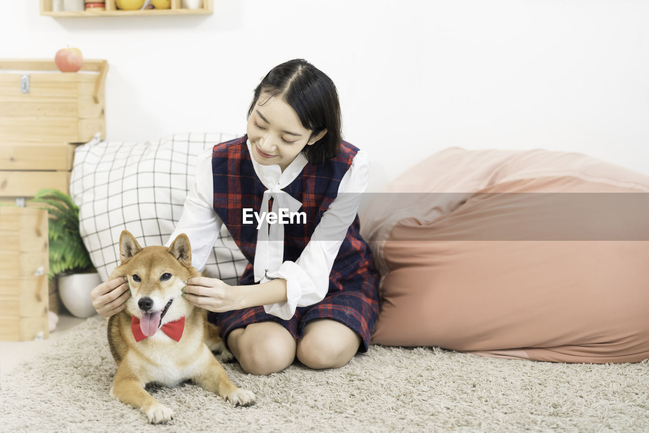 Pet lover concept. the girl is smiling with the shiba inu dog on in the living room. 