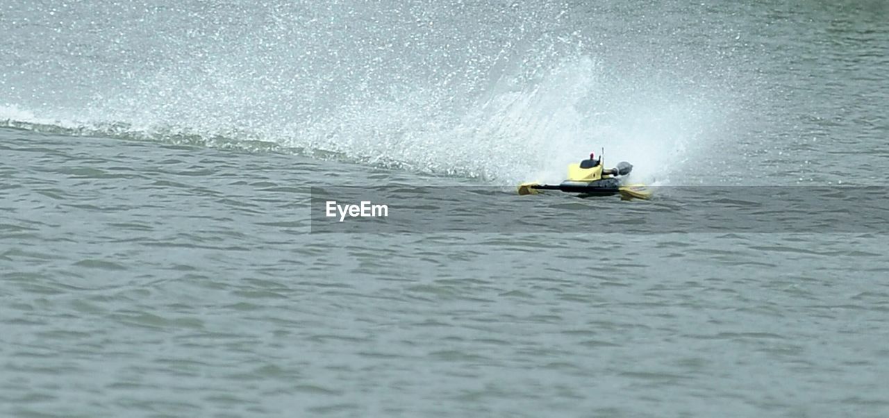 Motorboat splashing in sea against rock formation