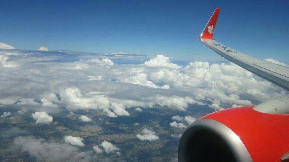 airplane, air vehicle, flying, transportation, mode of transportation, aircraft wing, aerial view, sky, air travel, cloud, vehicle, nature, travel, mid-air, environment, aircraft, day, on the move, no people, aviation, motion, blue, journey, scenics - nature, outdoors, landscape, beauty in nature, engine, wing, cloudscape, jet engine, airliner, red