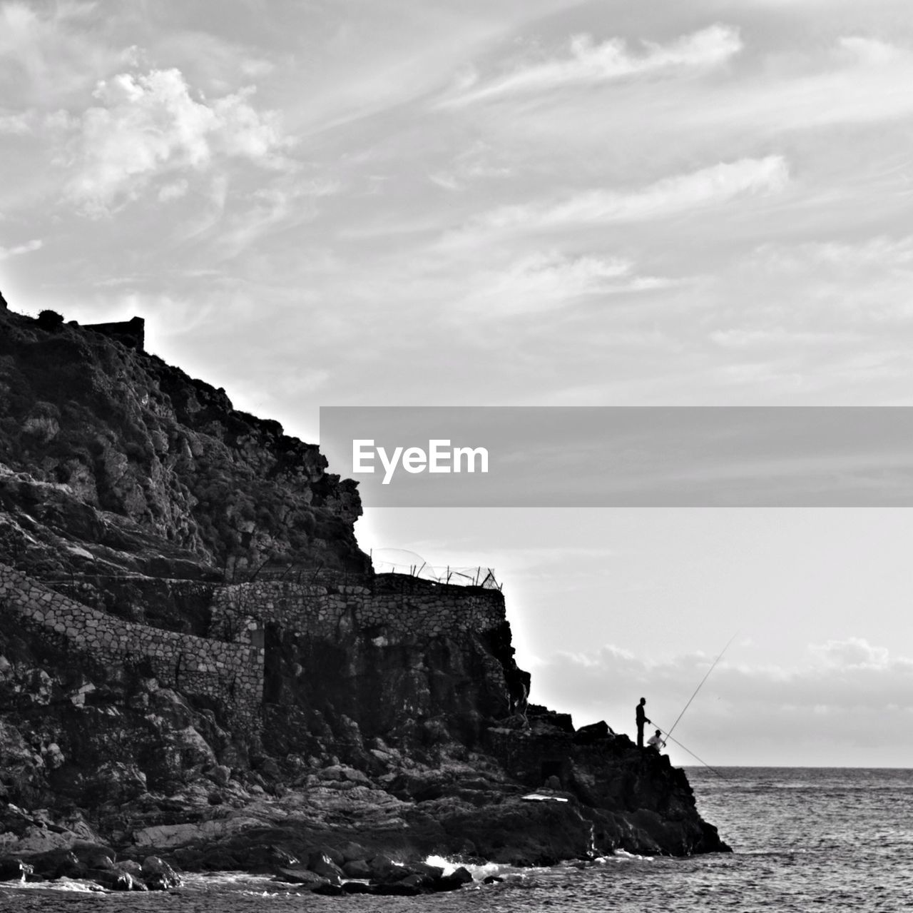 Two man fishing on rocky coast