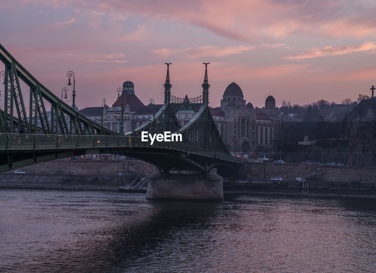 Bridge over river against cloudy sky