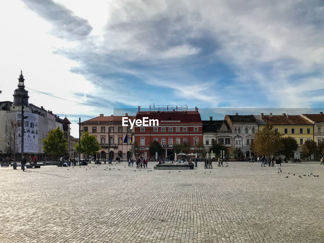 Buildings in town against cloudy sky