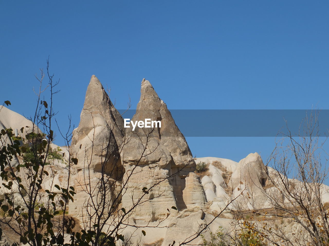 Low angle view of rock formation against clear blue sky