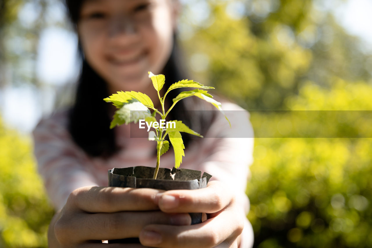 MAN HOLDING PLANT OUTDOORS