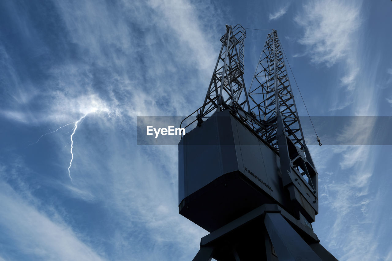 Low angle view of crane against sky