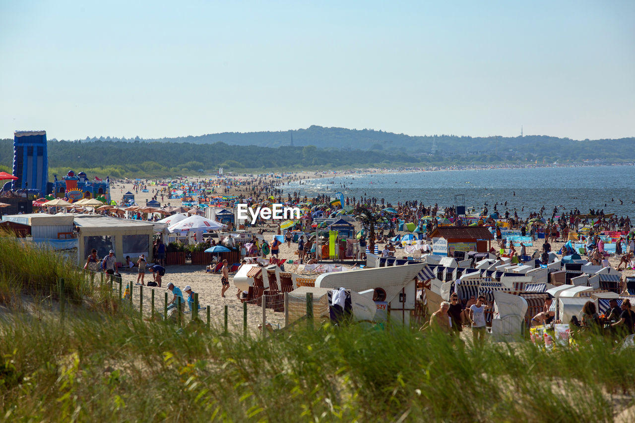 PEOPLE ON BEACH AGAINST SKY