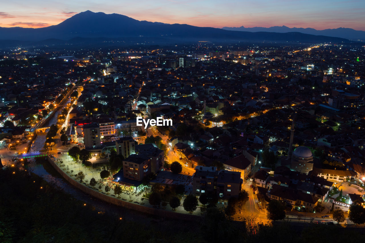 High angle view of illuminated cityscape against sky at night