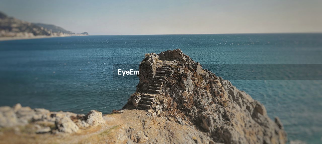 PANORAMIC VIEW OF ROCK FORMATION ON BEACH AGAINST SKY