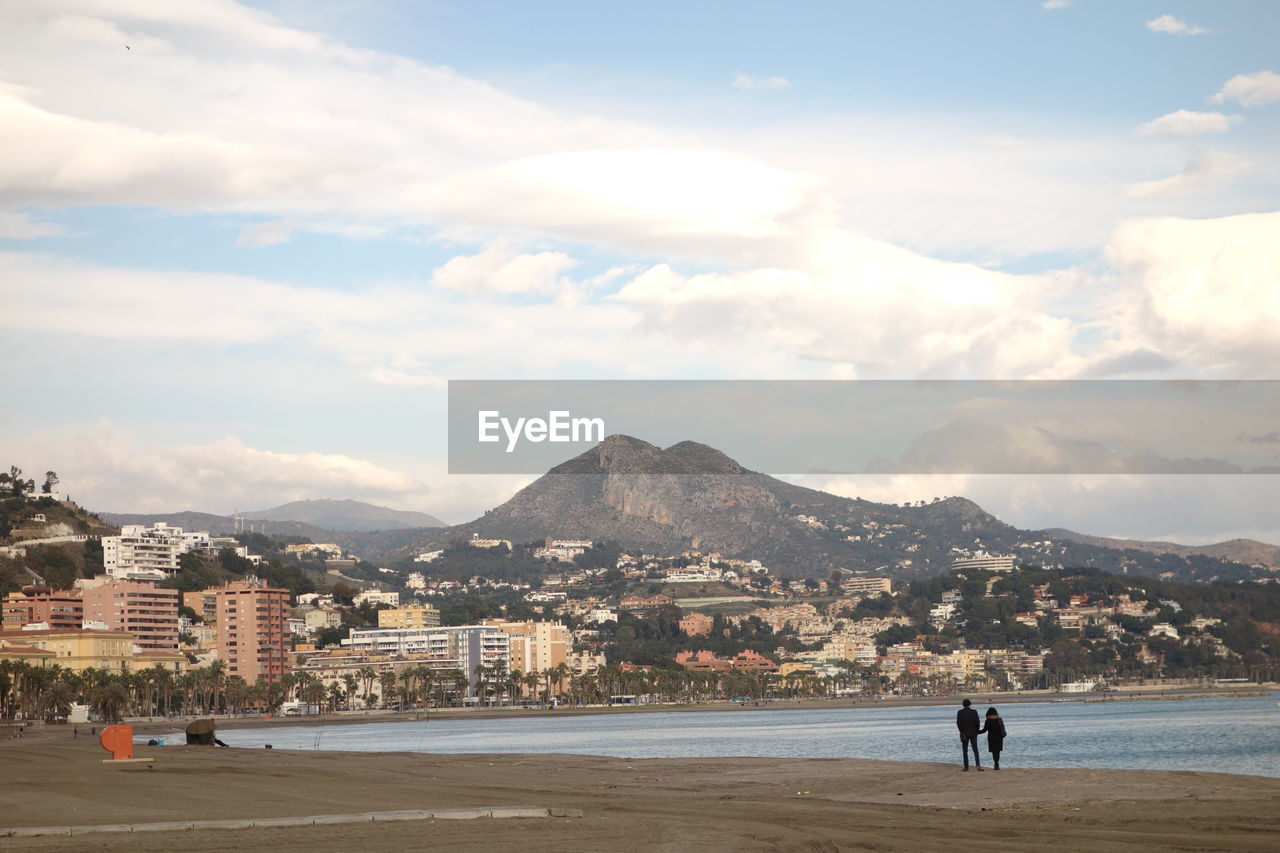 SCENIC VIEW OF BEACH BY MOUNTAINS AGAINST SKY